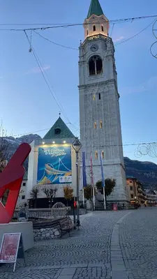 a large tower with a clock on top of it at 360-degree panoramic attic in Cortina in Cortina dʼAmpezzo