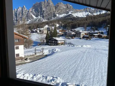 a view of a snowy mountain from a window at 360-degree panoramic attic in Cortina in Cortina dʼAmpezzo