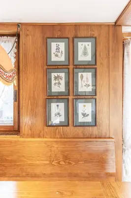 a wall with four framed drawings of trees at Casa Funivia 2, with panoramic balcony in Cortina dʼAmpezzo