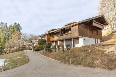 a house on a hill with a driveway at Casa Funivia 2, with panoramic balcony in Cortina dʼAmpezzo