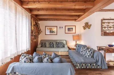 a living room with two couches and a couch at Casa Funivia 2, with panoramic balcony in Cortina dʼAmpezzo