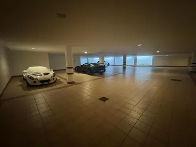 two cars are parked in a large garage at Ca Dei Nani - Exclusive stay with sauna in Cortina dʼAmpezzo