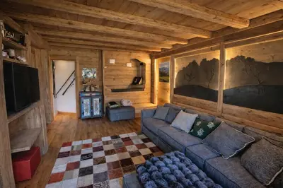 a living room with a couch and a tv at Ca Dei Nani - Exclusive stay with sauna in Cortina dʼAmpezzo
