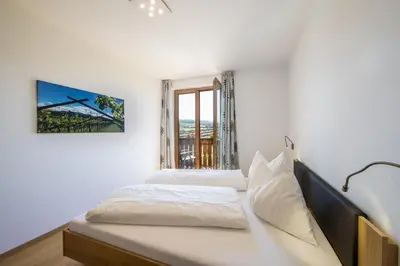 a bedroom with two beds and a window at Appartements Weisshauserhof in Appiano sulla Strada del Vino