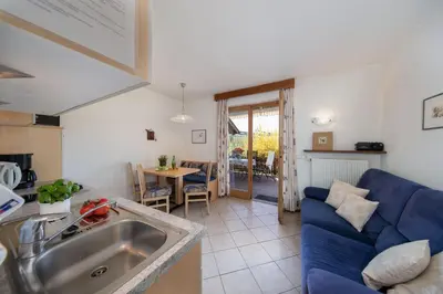 a kitchen and living room with a blue couch at Appartements Weisshauserhof in Appiano sulla Strada del Vino