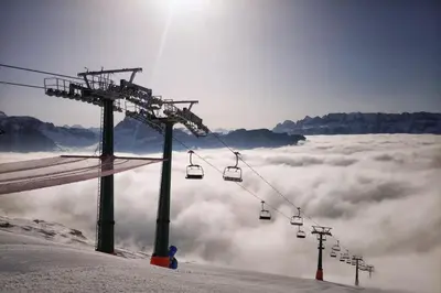 a ski lift on top of a mountain above the clouds at Chalet Center Pic in Ortisei