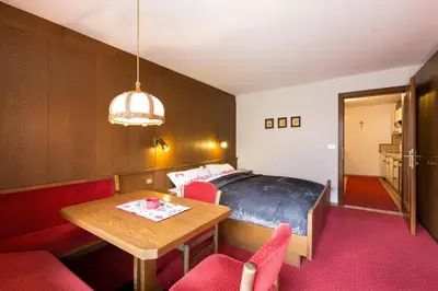 a bedroom with a bed and a table and chairs at Apartments Meisules in Ortisei