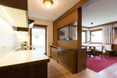 a kitchen with a table and a dining room at Apartments Meisules in Ortisei