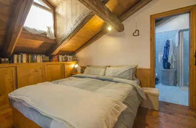 a bedroom with a large bed and a window at Un angolo di comfort nel pieno centro di Cortina in Cortina dʼAmpezzo