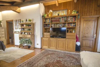 a living room with a television and book shelves at Un angolo di comfort nel pieno centro di Cortina in Cortina dʼAmpezzo