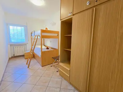 a bedroom with a bunk bed and a cabinet at Casa Iole - Alpine Stay Apartments in Predazzo