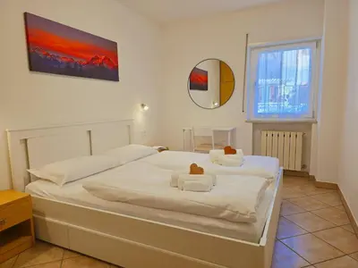 a bedroom with two beds and a mirror on the wall at Casa Iole - Alpine Stay Apartments in Predazzo