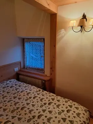 a bedroom with a bed and a window at Luminoso e ampio appartamento con vista sulle Dolomiti e Tofane in Cortina dʼAmpezzo
