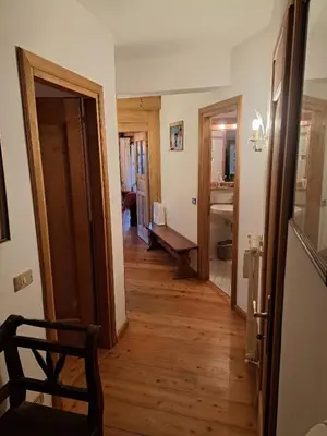 a hallway of a home with a wooden floor at Luminoso e ampio appartamento con vista sulle Dolomiti e Tofane in Cortina dʼAmpezzo