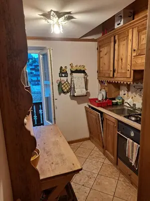 a kitchen with wooden cabinets and a counter top at Luminoso e ampio appartamento con vista sulle Dolomiti e Tofane in Cortina dʼAmpezzo