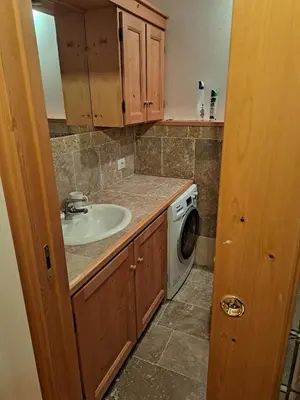 a bathroom with a sink and a washing machine at Luminoso e ampio appartamento con vista sulle Dolomiti e Tofane in Cortina dʼAmpezzo