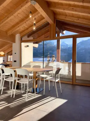 a dining room with a table and chairs and a large window at Appartamento LITEGOSA 2 in Panchia