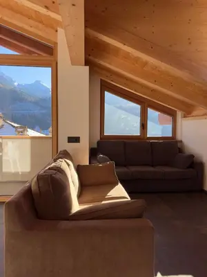 a living room with a couch and large windows at Appartamento LITEGOSA 2 in Panchia