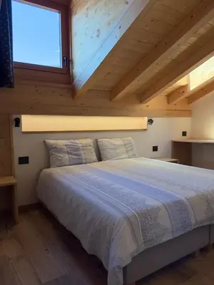 a bedroom with a large bed with a window at Appartamento LITEGOSA 2 in Panchia
