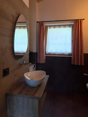 a bathroom with a bowl sink and a window at Appartamento LITEGOSA 2 in Panchia