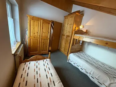 a small room with a bed and a wooden cabinet at Casa di Lilly in Moena
