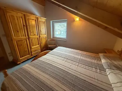 a bedroom with a bed and a window at Casa di Lilly in Moena