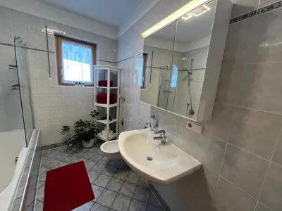 a bathroom with a sink and a shower and a toilet at Mountain River Apartment in Chienes