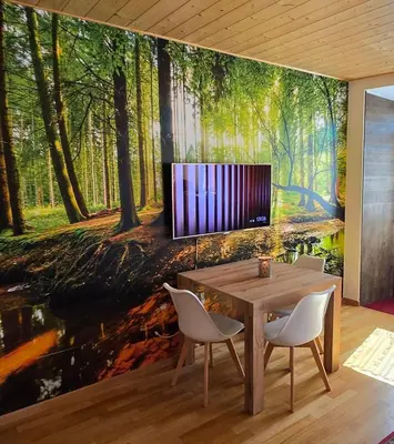 a dining room with a painting of a forest at Maison Cavalese - Wild Forest, tranquillità a due passi dal centro in Cavalese