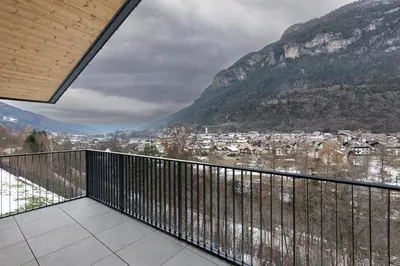 a balcony with a view of a town and mountains at FIEMME IN VISTA Apartments in Ziano di Fiemme