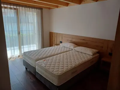 a bedroom with a bed and a large window at FIEMME IN VISTA Apartments in Ziano di Fiemme