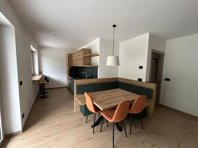 a kitchen and dining room with a table and chairs at FIEMME IN VISTA Apartments in Ziano di Fiemme
