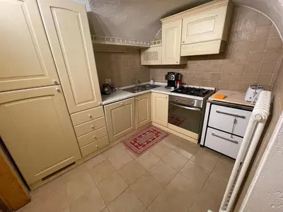 a kitchen with white cabinets and a stove top oven at Rustico NaturaViva in Valfloriana