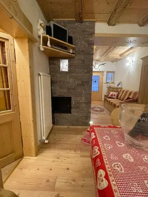 a living room with a stone fireplace and a table at Rustico NaturaViva in Valfloriana