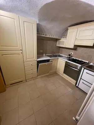 a kitchen with white cabinets and a stove top oven at Rustico NaturaViva in Valfloriana