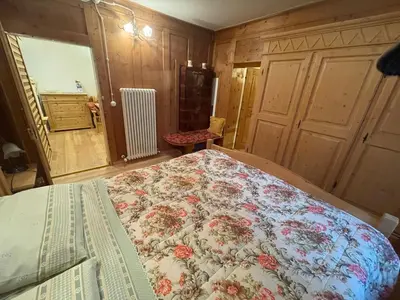 a bedroom with a bed with a floral bedspread at Rustico NaturaViva in Valfloriana