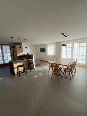 a room with a table and chairs and a kitchen at Villa Moroseta in Tesero
