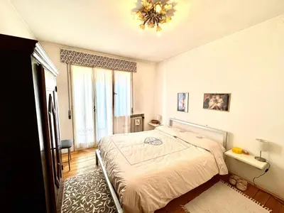 a bedroom with a bed and a chandelier at Ca Radiosa - Via Guide Alpine in Cortina dʼAmpezzo