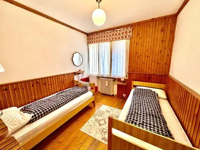 two beds in a room with wooden walls at Ca Radiosa - Via Guide Alpine in Cortina dʼAmpezzo