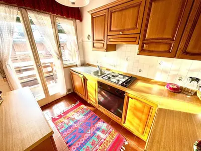 a kitchen with wooden cabinets and a stove top oven at Ca Radiosa - Via Guide Alpine in Cortina dʼAmpezzo