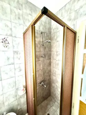 a shower with a glass door in a bathroom at Ca Radiosa - Via Guide Alpine in Cortina dʼAmpezzo