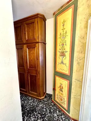 a room with a wooden cabinet next to a wall at Ca Radiosa - Via Guide Alpine in Cortina dʼAmpezzo