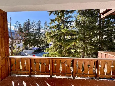 a balcony with a view of a street and trees at Villa Augusta-central apartment in Cortina dʼAmpezzo
