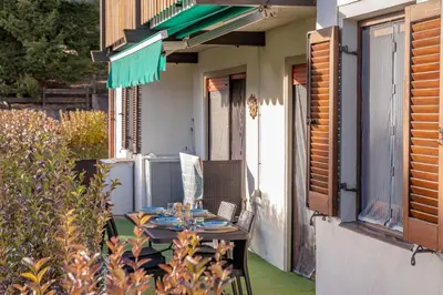 a table and chairs on the porch of a house at Trilo Ciasa Brìma in Carano