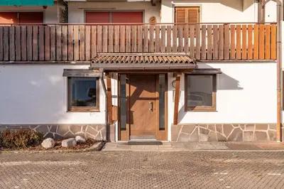 a house with a wooden door and a wooden fence at Trilo Ciasa Brìma in Carano