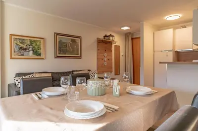 a dining room table with plates and glasses on it at Trilo Ciasa Brìma in Carano