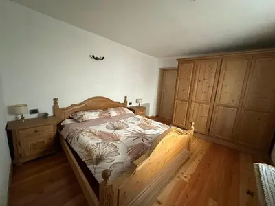 a bedroom with a wooden bed and wooden cabinets at Il nido delle cime in Capriana