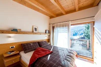 a bedroom with a bed and a large window at Awakening in the Dolomites between Pelmo and Antelao in Borca di Cadore