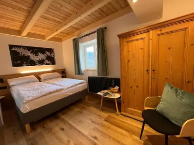 a bedroom with a bed and a chair at Mas dal Vent in Valfloriana