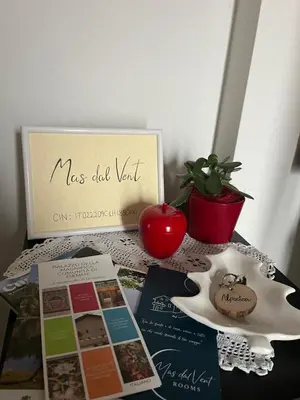 a table with a sign and a potted plant at Mas dal Vent in Valfloriana