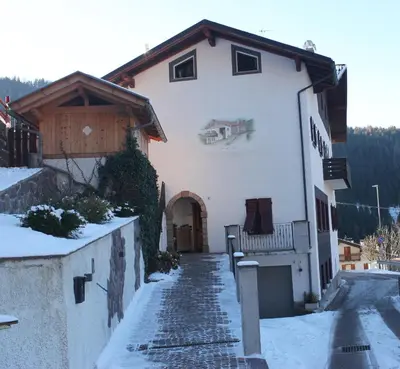 a white house with snow on the ground at Mas dal Vent in Valfloriana